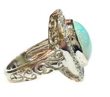 Custom engagement ring with client opal and diamonds set in 14k white gold, side view.
